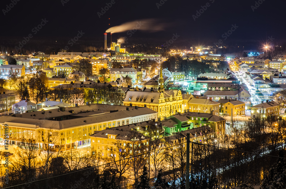 View of small swedish european town Soderhamn at night, industrial background with evening illumination