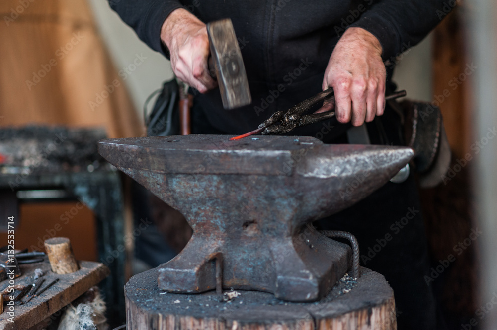 Blacksmith at the workshop. Working metal with hammer and tools on the anvil in the forge. Blacksmith at the workshop. Working metal with hammer and tools on the anvil in the forge.