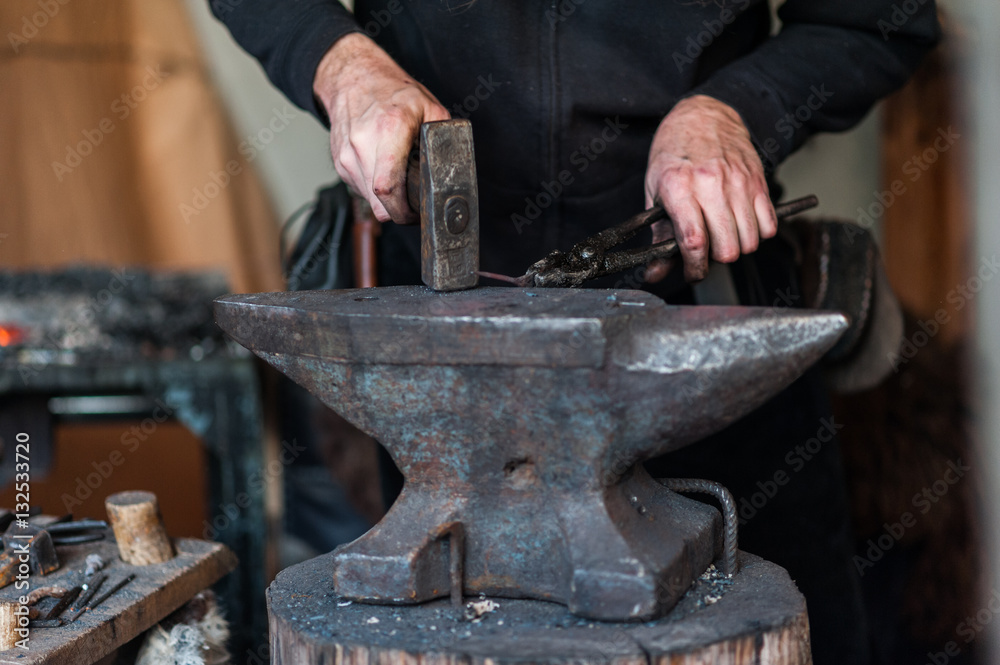Blacksmith at the workshop. Working metal with hammer and tools on the anvil in the forge. Blacksmith at the workshop. Working metal with hammer and tools on the anvil in the forge.