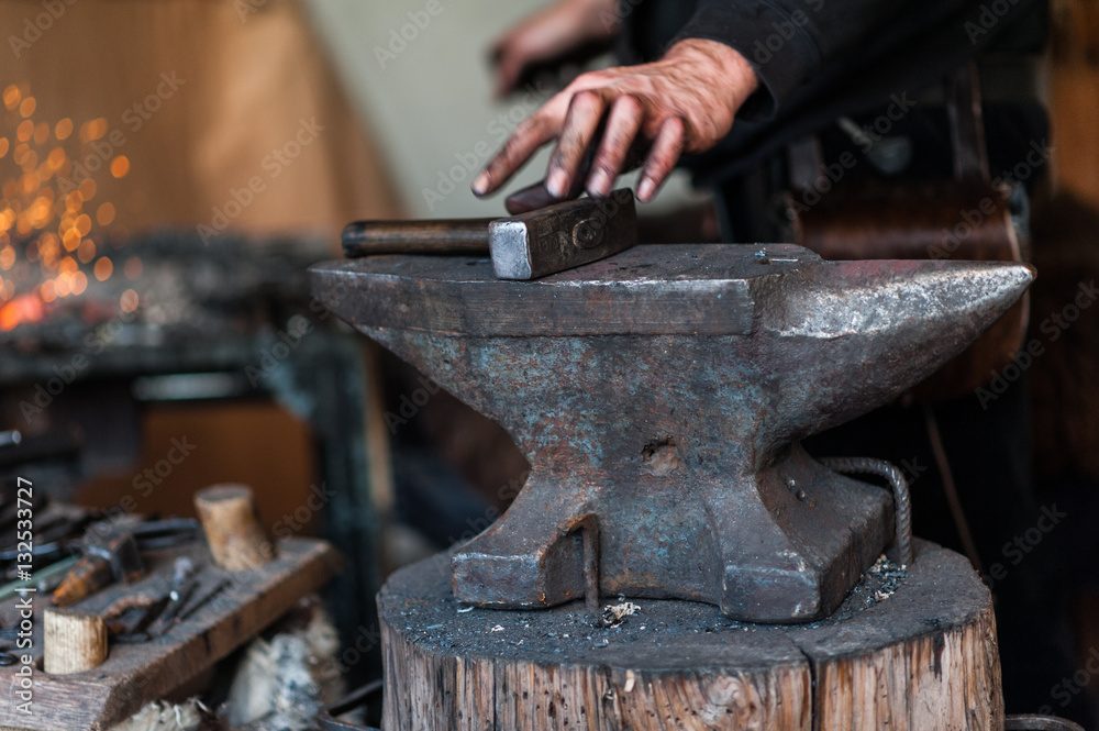 Blacksmith at the workshop. Working metal with hammer and tools on the anvil in the forge. Blacksmith at the workshop. Working metal with hammer and tools on the anvil in the forge.