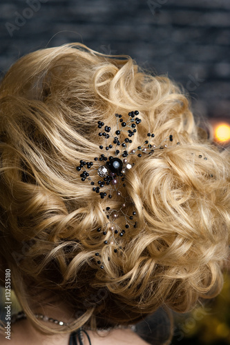 beautiful evening hairstyle on blonde hair with black decoration of stones