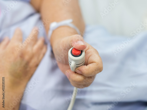 A hand holding emergency button in hospital room.Emergency button for hospital patients.