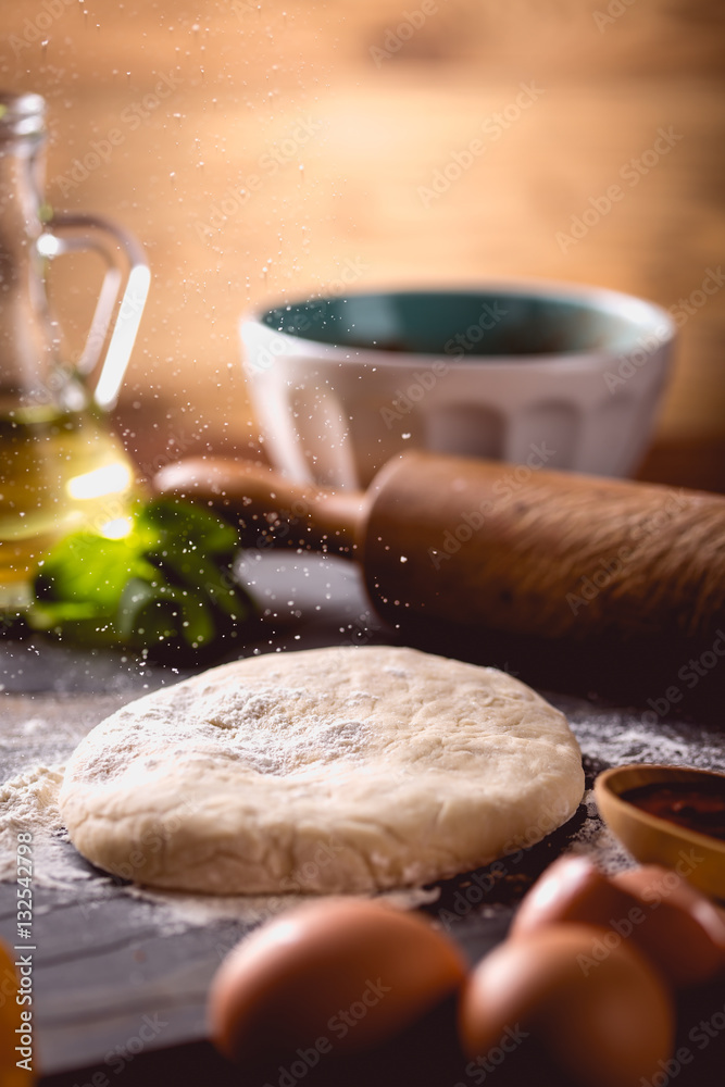Dough with flour on wooden table, preparing homemade pizza Dough with flour on wooden table, preparing homemade pizza