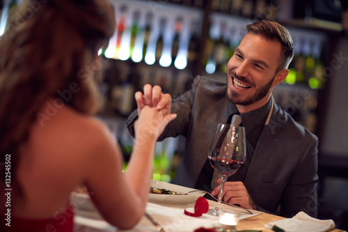 Very happy man engaged girlfriend in restaurant