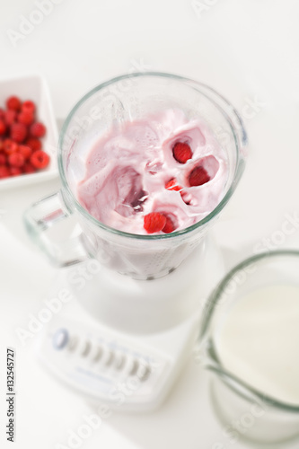 berries dropped into blender full of smoothy