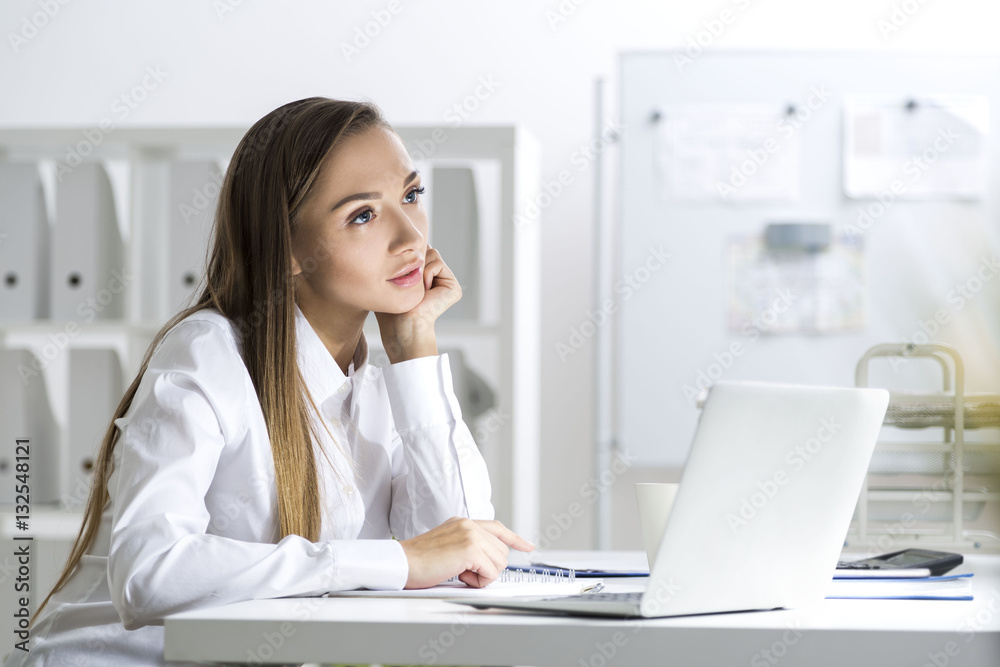 Businesswoman daydreaming in a white office