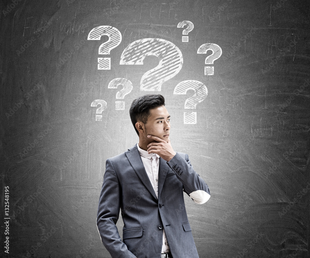 Asian businessman, question marks, chalkboard