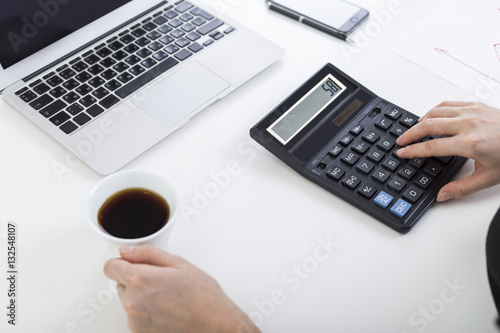 Woman with coffee and a calculator