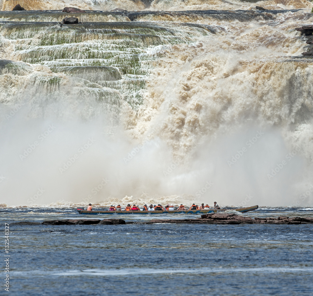 Fototapeta premium The powerful falls and tourists boat in the lagoon of the Canaima national park - Venezuela, South America