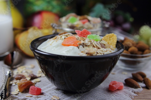 домашний йогурт и мюсли с кусочками сушеных фруктов и миндалем.полезный завтрак