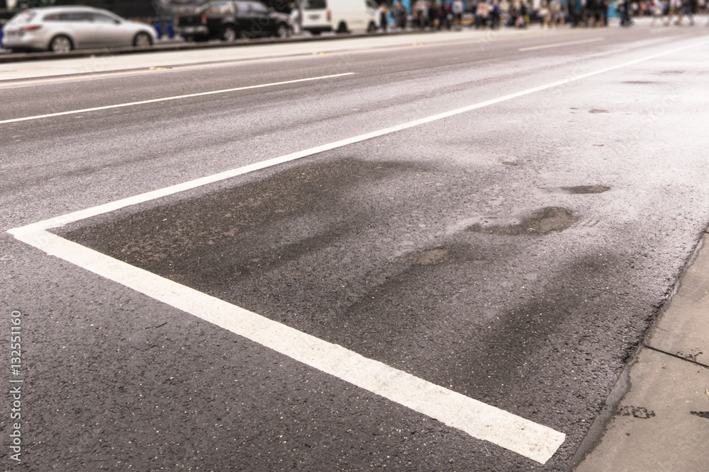 A wet road with road marks in the busy city.