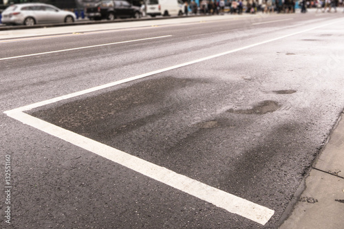 A wet road with road marks in the busy city.