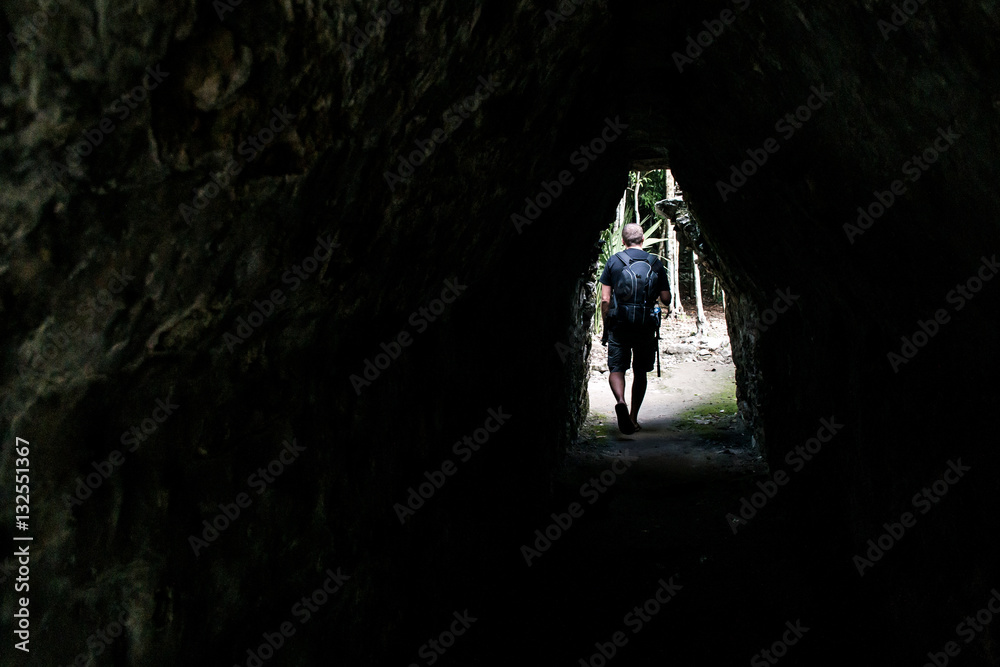 Men walking tunnel Coba Mayan Ruins in Mexico Yucatan