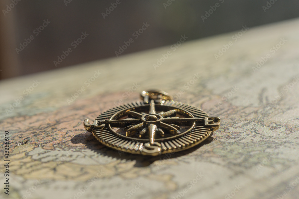 Closeup of vintage compass lying on an old world map