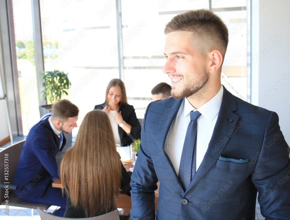 Businessman with colleagues in the background in office Businessman with colleagues in the background in office