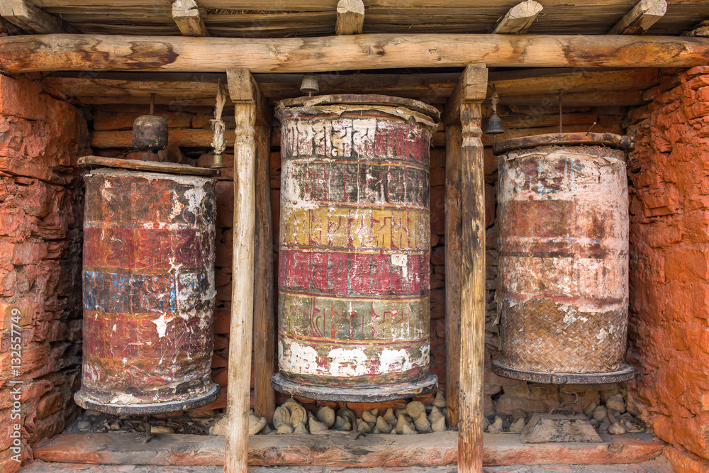 Buddhist prayer mani wall with prayer wheels in nepalese village on the Annapurna circuit trekking route, Nepal Buddhist prayer mani wall with prayer wheels in nepalese village on the Annapurna circuit trekking route, Nepal