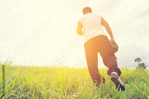 Man running and towel in his hand and nature background view.