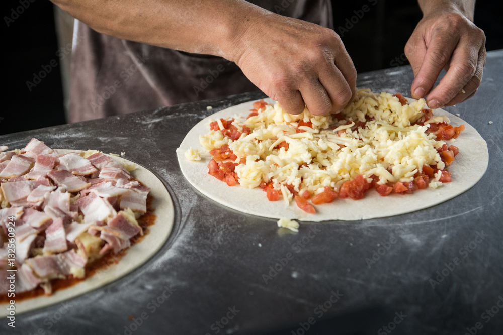 Hands preparing a pizza (dark background) Hands preparing a pizza (dark background)