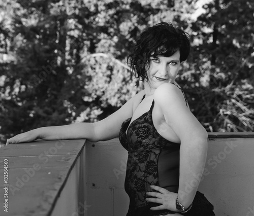 Obraz na plátně Curvy model in intimate clothing poses outdoors with a sexy and provocative pose