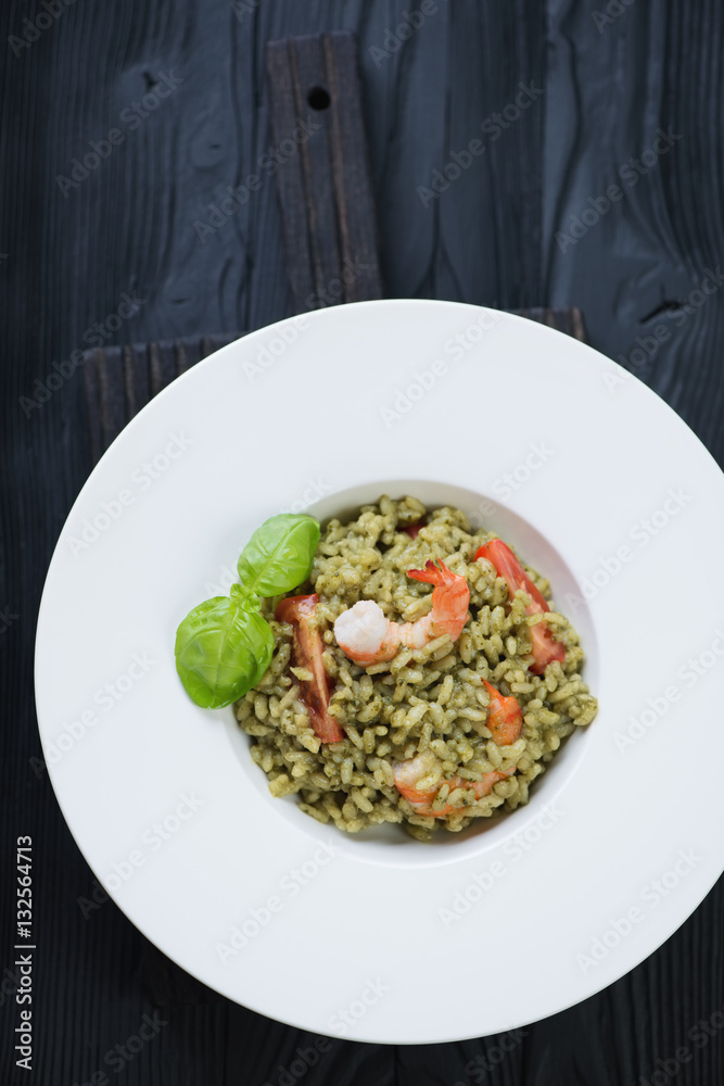 Above view of spinach and tiger shrimps risotto in a white plate Above view of spinach and tiger shrimps risotto in a white plate