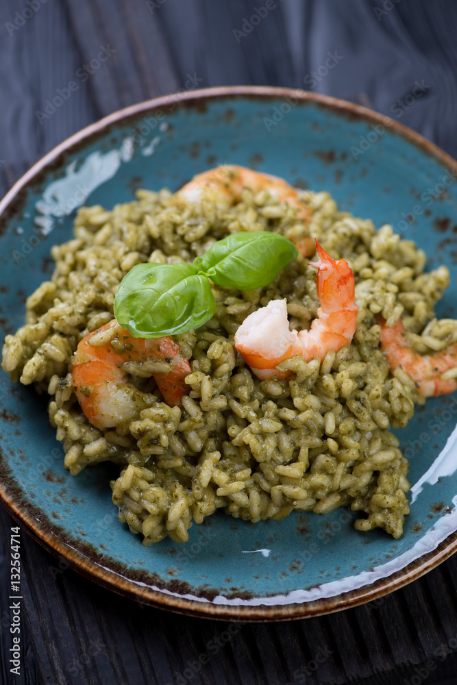 Close-up of italian risotto with spinach and tiger shrimps