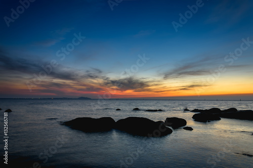 Rocks at sea side with silhouette theme sunset sky © arnuphapy