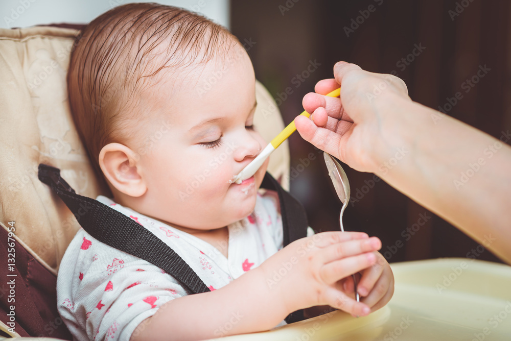 mother feeding her baby breast porridge day