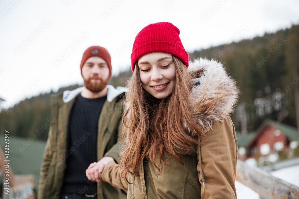 Young cheerful loving couple walking over mountains