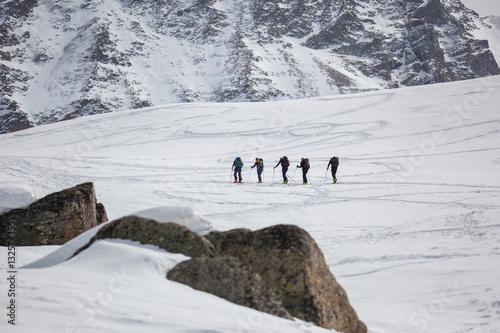 Sci alpinisti in salita su pendio innevato photo