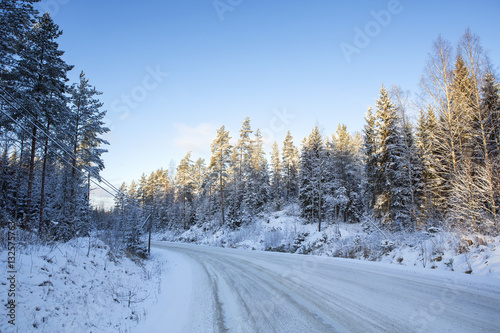 Traveling to the winter wonderland. An image of a snowy road in the countryside on a sunny winter day.