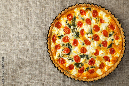 Vegetarian homemade pie, Quiche with tomatoes, spinach and feta cheese.