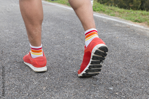 athletic young man running on road in the park. Healthy lifestyl