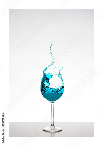 türkis farbener Wassersplash im Glas mit Spritzern - Liquid Art, Weinsplash im Glas photo