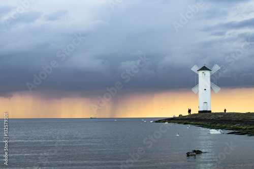 storm passing over the lighthouse at sunset