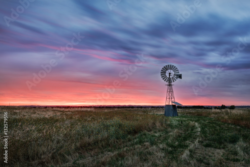 Beautiful sunset falling behind a windmill. photo