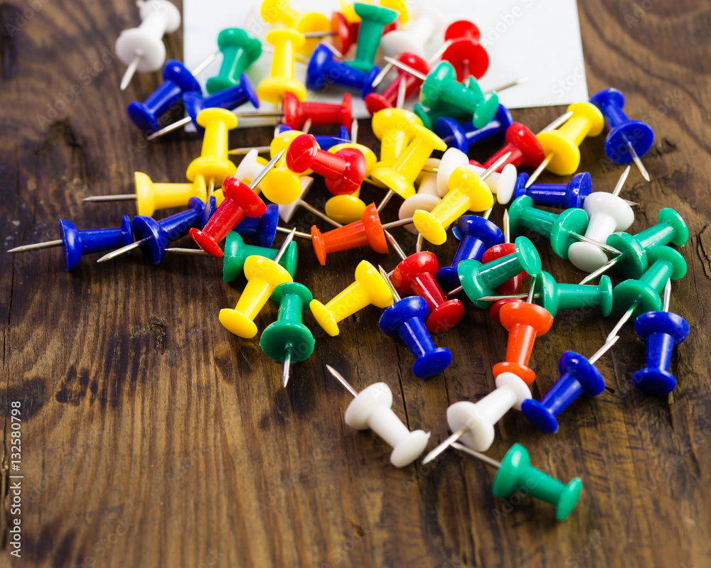 Various color thumbtacks and note on distressed wood Various color thumbtacks and note on distressed wood