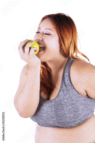Overweight woman eats apple fruit