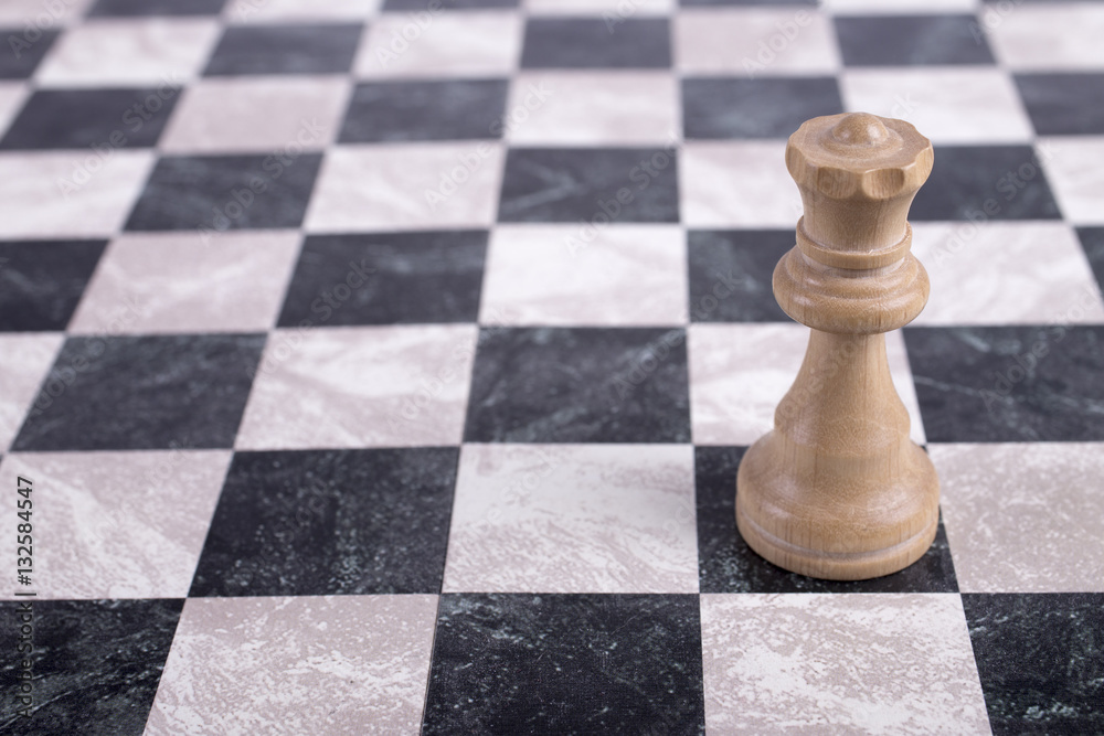 white wooden queen on chessboard