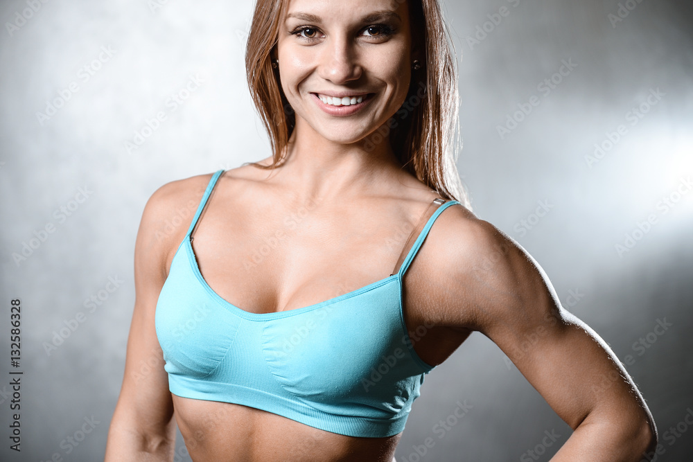beautiful fitness model posing in studio on white grey backgroun beautiful fitness model posing in studio on white grey backgroun