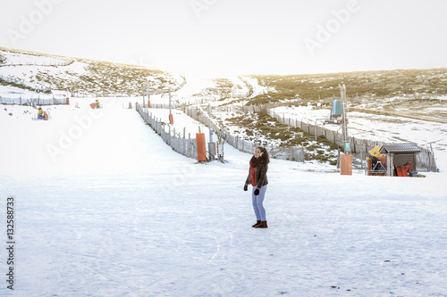 Vacaciones en la nieve. Mujer joven a los pies de la pista de esquí