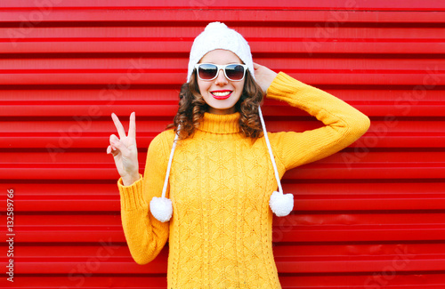 Fashion smiling young woman wearing colorful knitted yellow swea photo