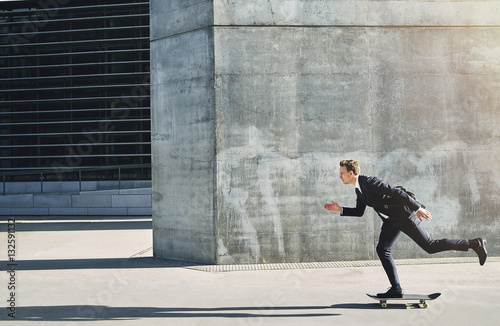 Businessman on a skateboard moving forward fast photo