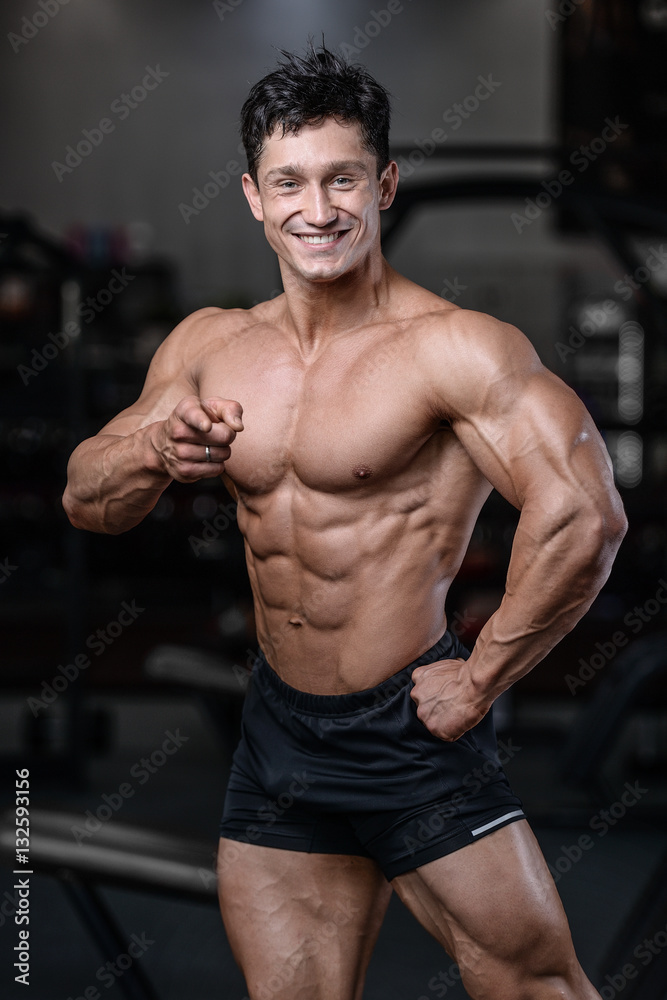 Handsome bodybuilder training in the gym sexy man lift dumbbells Handsome bodybuilder training in the gym sexy man lift dumbbells