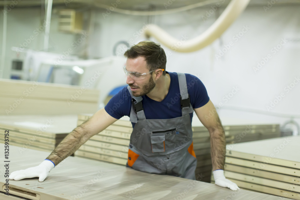 Handsome young man working in the lumber factory Handsome young man working in the lumber factory
