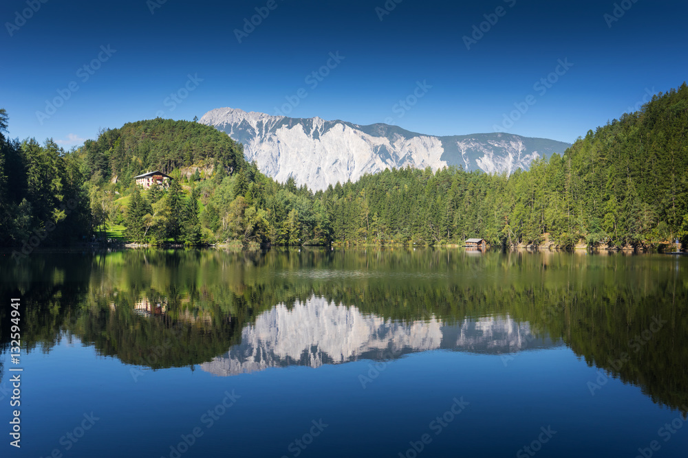 Landscape protection area Achstürze. Lake Piburger See and alps in the background. Tirol oldest nature preserves. Oetz alps, unique cultural mountains landscape. Ötztal valley.