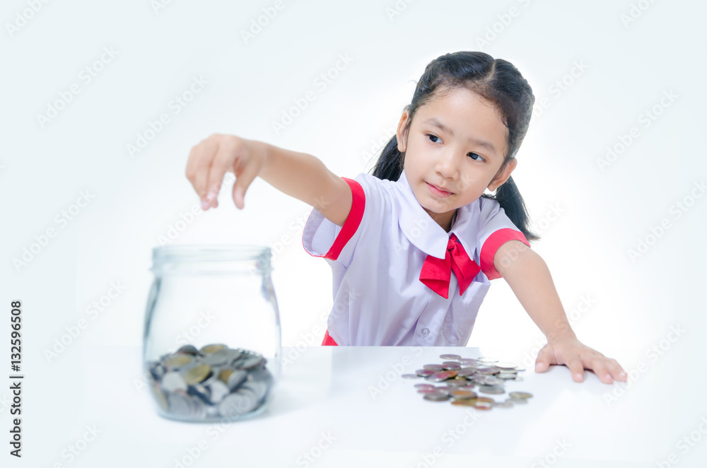 Asian little girl in Thai student uniform putting coin to glass Asian little girl in Thai student uniform putting coin to glass