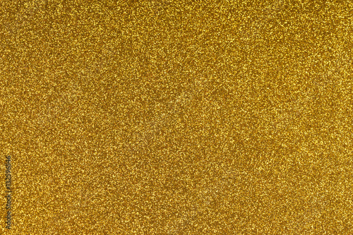 Glittering gold paper sheet texture background. Sparkling golden yellow pattern.