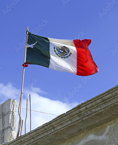 Mexican country flag on top of construction site, Mexico