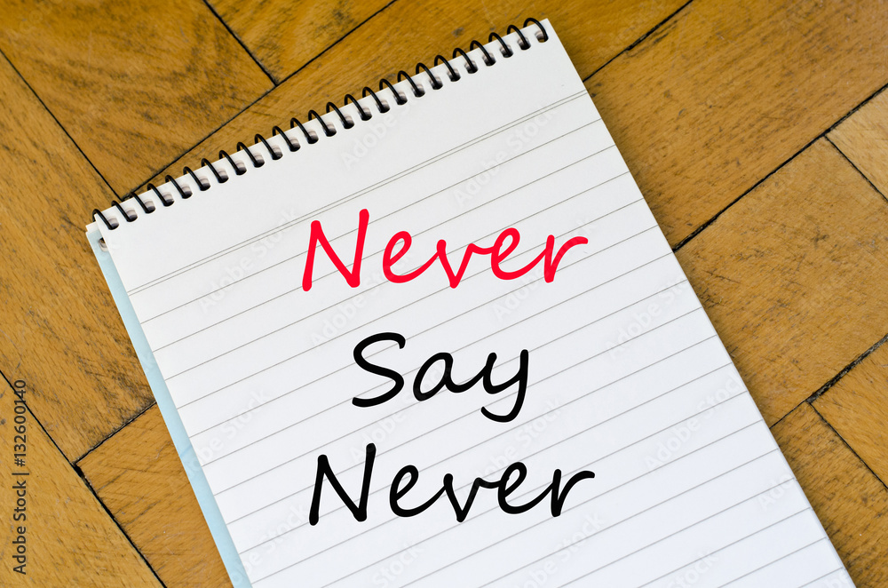 Human hand over wooden background and never say never text conce Human hand over wooden background and never say never text conce
