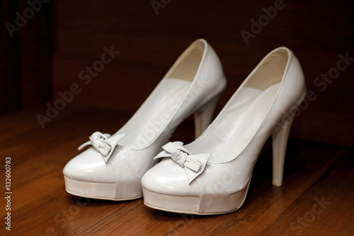 White female shoes with high heels standing on a table